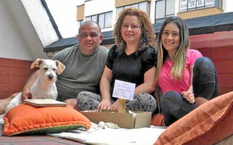 Valentina Gálvez Gómez junto con sus padres, Jhon y Viviana, y su perro Max muestran el pícnic que elaboraron en la terraza de s