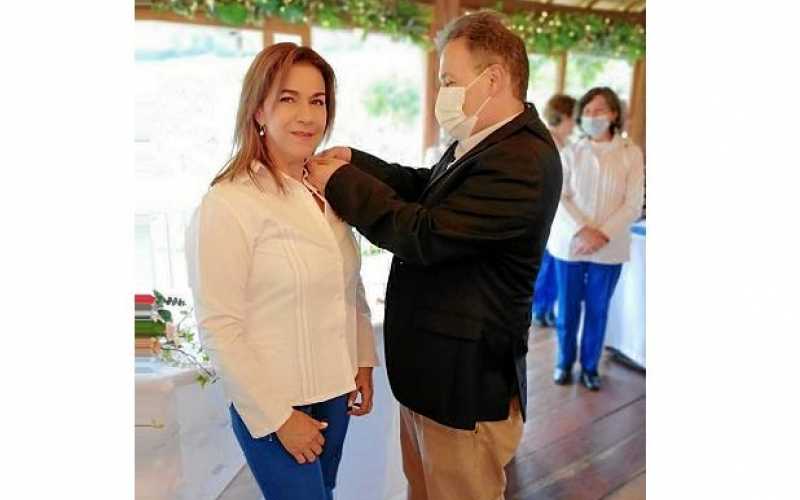 La voluntaria Martha Lucía Trejos recibe el botón de 10 años de manos del gerente de Avidanti, Carlos Hernán Estrada.